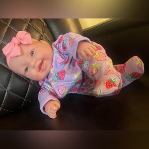 Weighted baby doll, she’s approximately 3lbs, 2oz, and wears preemie clothing.